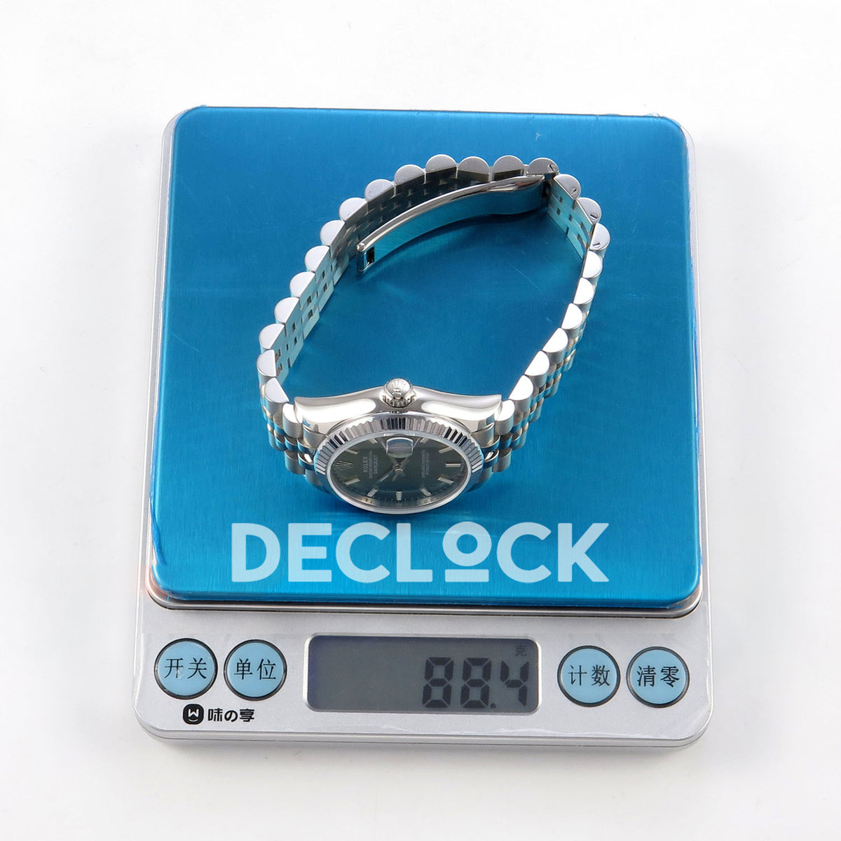 Rolex Datejust 31 278274 Green Stick Jubilee XRF A2236 replica - Watch on a blue weighing scale with its original LCD reading and gram unit visible